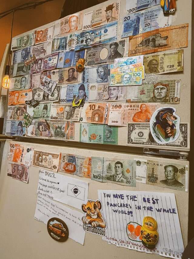 Fridge covered in international currency and guest notes at Northern Cafe”